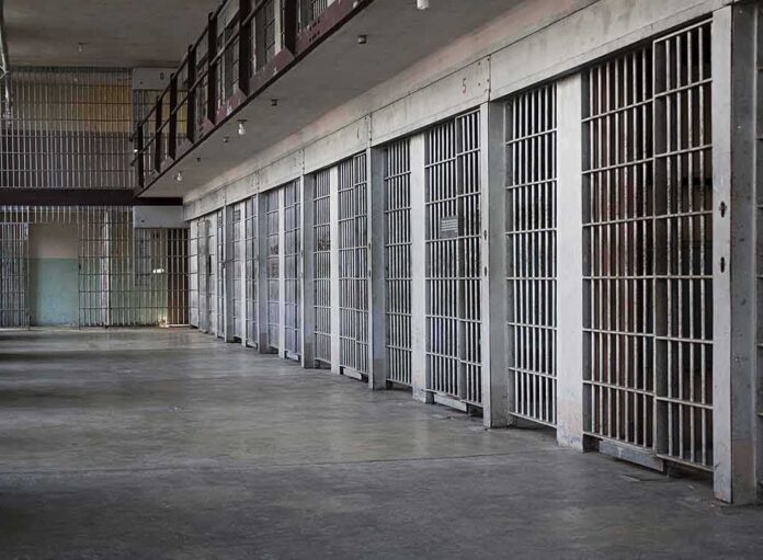shutterstock_100994692 prison cell block with metal barred doors
