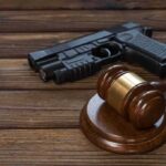 Gavel and handgun on wooden table