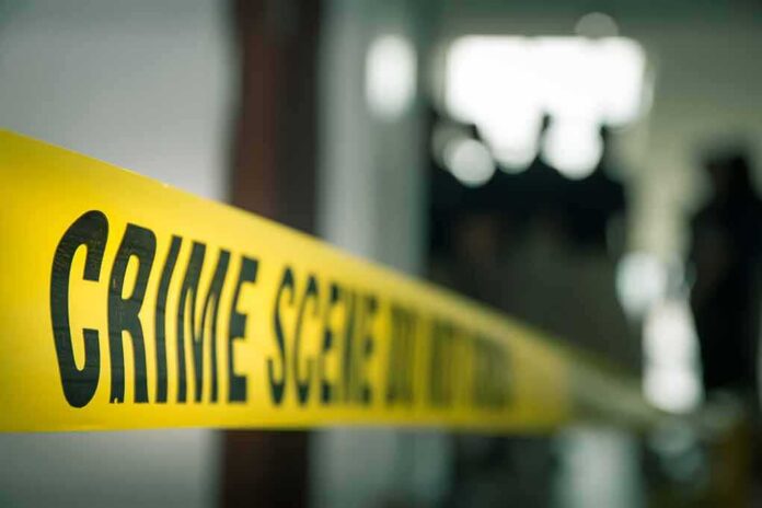 shutterstock_1154369989 crime scene tape in a blurred indoor setting