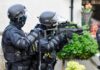 Belfast Riots Expose Rise in Anti-Migrant Hate armed police officers aiming rifles during operation