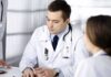 Doctors in white coats discuss patient case at a table