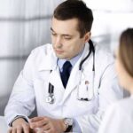 Judge Lets Doctor’s Speech Fight Continue Doctors in white coats discuss patient case at a table