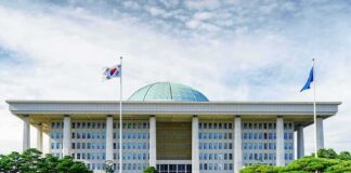 Parliament building with a green dome and flagpoles
