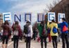 Spain Busts Major Migrant-Smuggling Network Group of people holding signs spelling ENOUGH at a street protest