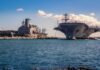 U.S. Forces Sink Alleged Cartel Refueling Vessel Aircraft carrier and support ships docked at a naval harbor