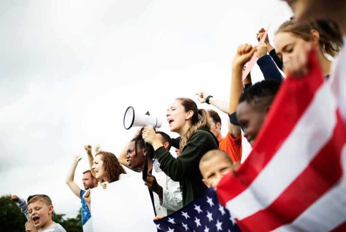 Group of people protesting with a megaphone and flag