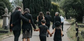 Mourners walking together through a cemetery path