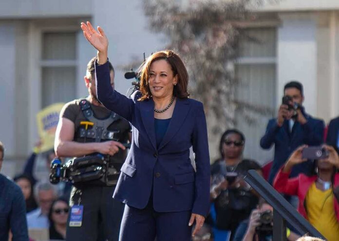 woman in navy suit waving at an outdoor event