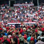 Crowd at a political rally facing a podium