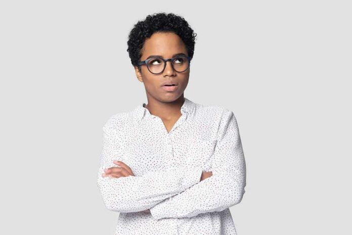 Person with glasses crossing arms and looking up