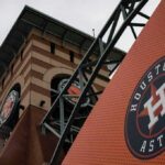 Houston Astros logo on orange sign near ballpark clock tower