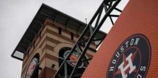 Houston Astros logo on orange sign near ballpark clock tower