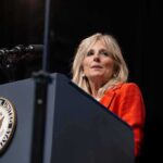 Woman speaking at a podium with a U.S. government seal