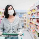 Lettuce Probe Intensifies as Cases Climb Woman wearing mask shopping in a supermarket aisle