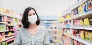Woman wearing mask shopping in a supermarket aisle