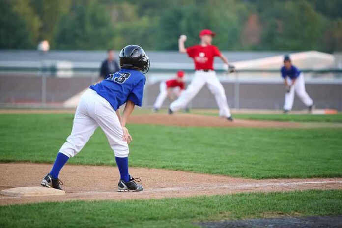 shutterstock_177056369 Young baseball player in blue uniform preparing to run on the field