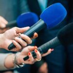 Fresno Plane Crash Leaves Three Dead Reporters holding colorful microphones