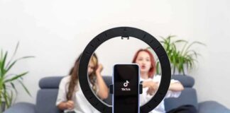 smartphone on ring light filming two people on a couch