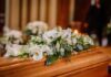 Genocide General’s Burial Sparks EU Backlash Coffin with white floral arrangement