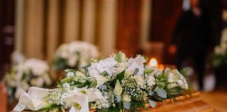 Coffin with white floral arrangement