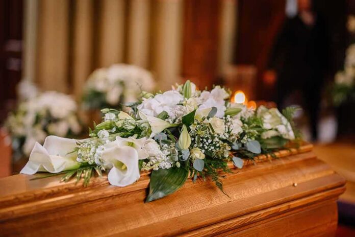 Coffin with white floral arrangement