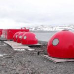 Red dome shelters at a polar research station by the sea