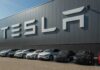 Tesla Unveils $30,000 Cybercab Robotaxi Tesla cars parked outside a large Tesla building