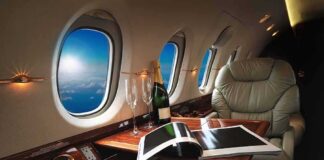 private jet cabin with leather seat, champagne and magazine on table