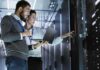 City Quiet, Data Centers Surge IT technicians inspect server racks in a data center aisle