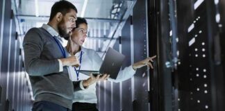 IT technicians inspect server racks in a data center aisle