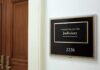 Surveillance CEOs Skip Senate Hearing Office sign for judiciary committee beside wooden doors