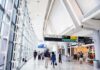 Airport terminal hallway with travelers and signage