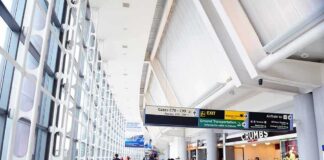 Airport terminal hallway with travelers and signage