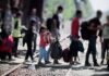 New Migrant Caravan Heads North Through Mexico People with bags walking along railway tracks