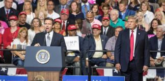 Ron DeSantis speaks at a rally podium as Donald Trump stands nearby; Badri Patarkatsishvili in the crowd