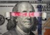portrait on banknote with torn strip revealing red eyes