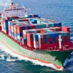U.S. Enforces Iran Blockade With Fourth Ship Strike A large cargo ship loaded with colorful containers sailing on the ocean