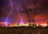 America’s Grid Faces a High-Impact EMP Risk Lightning strikes illuminate a power station against a colorful sunset sky