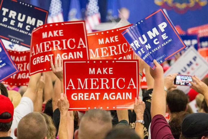 shutterstock_530768257 Crowd holding red and blue campaign signs at a political rally