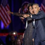 Obama Targets Michigan as Early Voting Opens Michelle Obama and Rob Nabors pointing on stage at an event